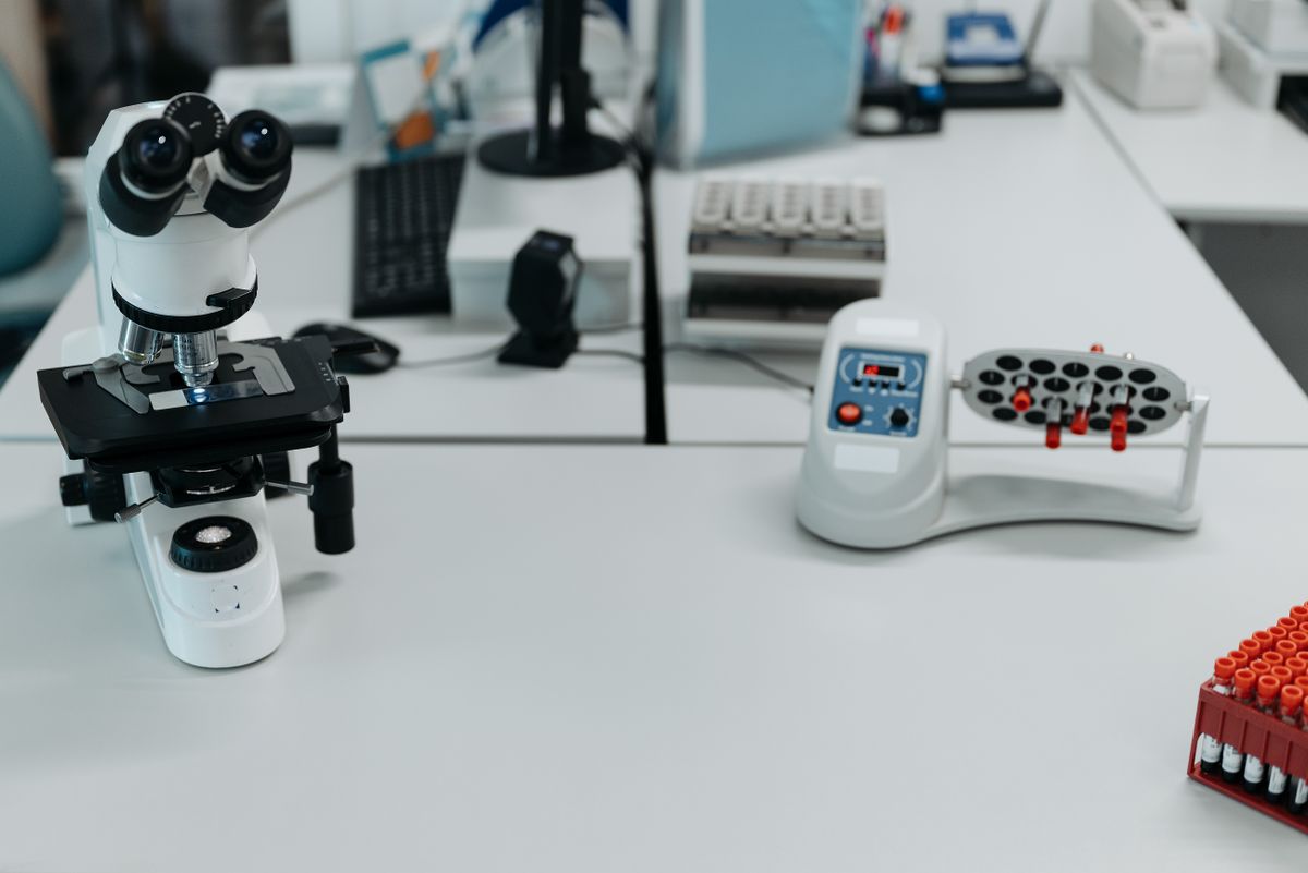 Microscópio e amostras em laboratório de análises clínicas.
